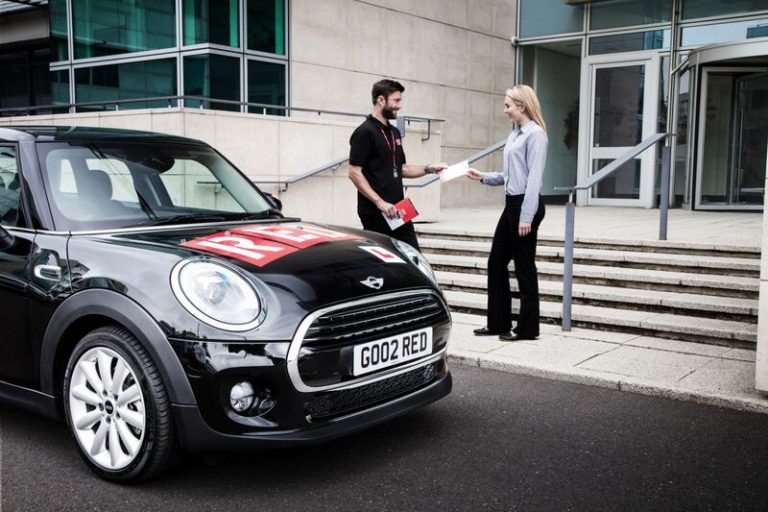 Man and woman next to black RED mini